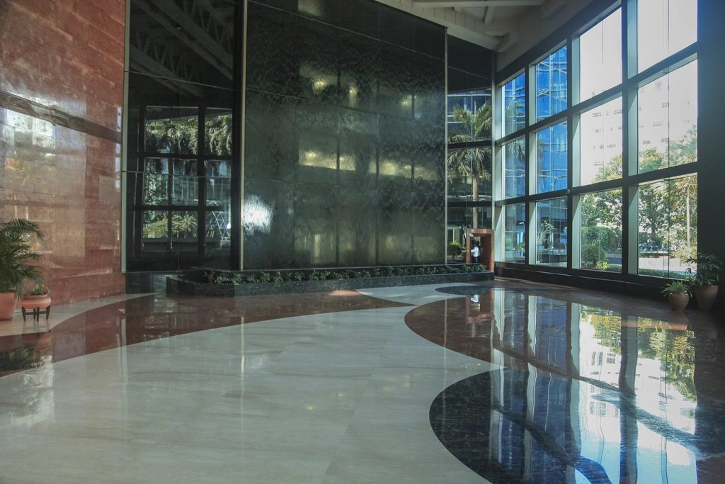 Glazed curtain-wall lobby entrance with full-height framed doors and a polished floor