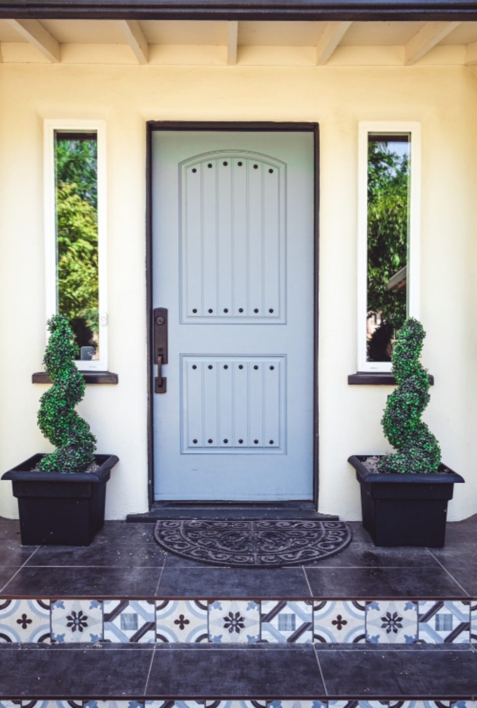 Panelled unit entry door with side lights above a patterned tiled threshold