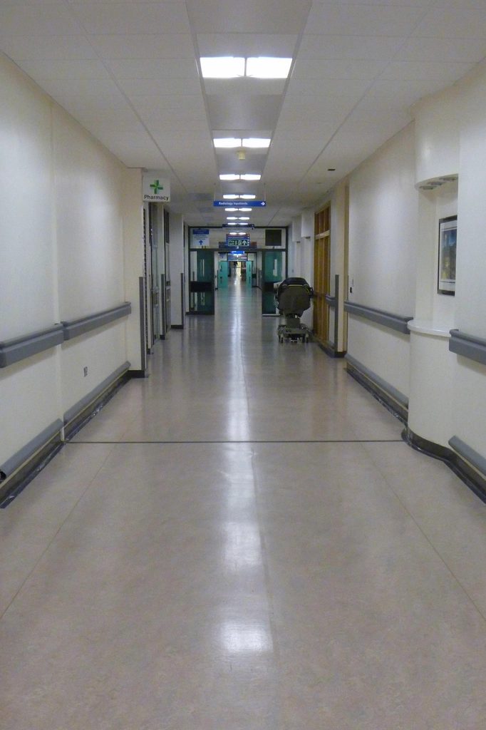 Clinical corridor with wall protection rails and doors receding in perspective