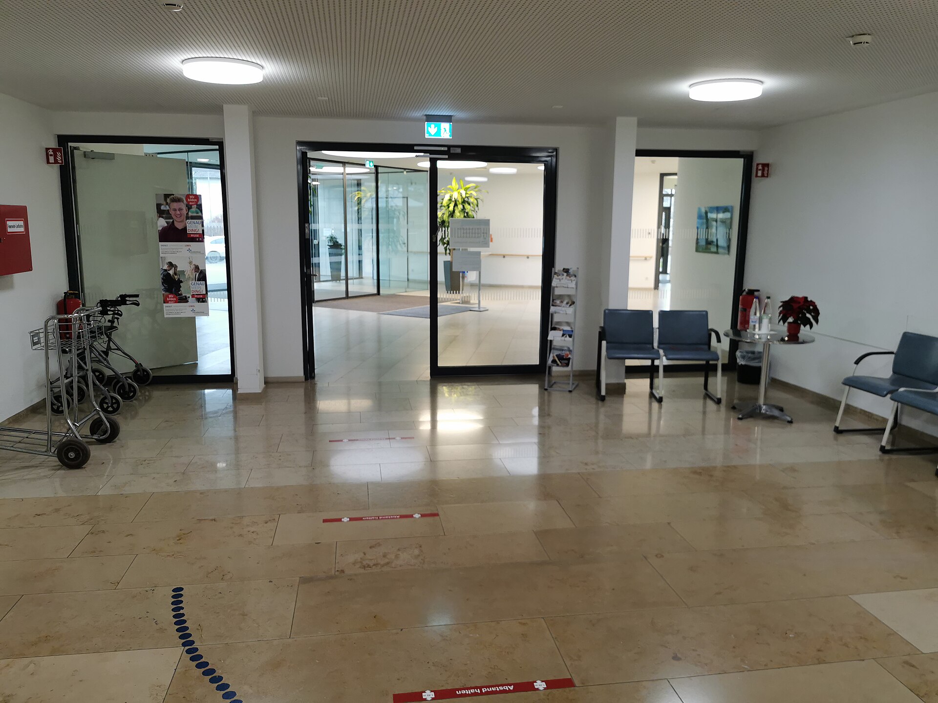 Glazed automatic sliding doors forming an internal hospital lobby threshold