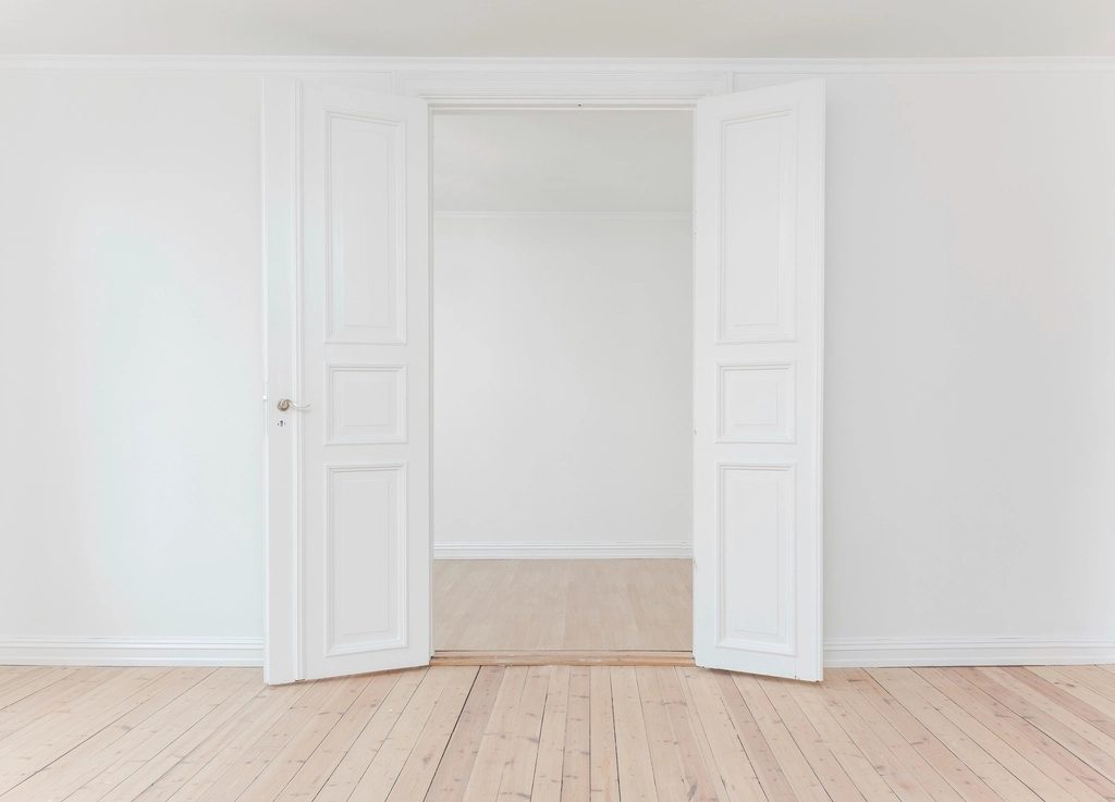 White double door assembly with full-height frame in an empty interior