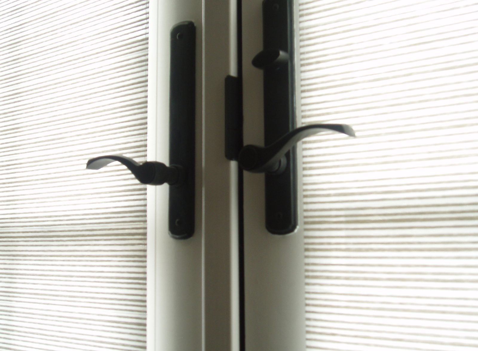 Close-up of paired lever handles on the meeting stiles of a double door